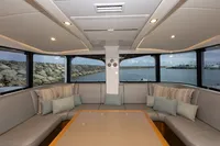 Luxurious interior of 2018 Tag 60 yacht with panoramic windows and plush seating.