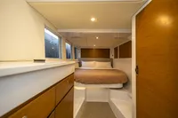 Interior of 2018 Tag 60 boat cabin with cozy bed and wooden cabinets.