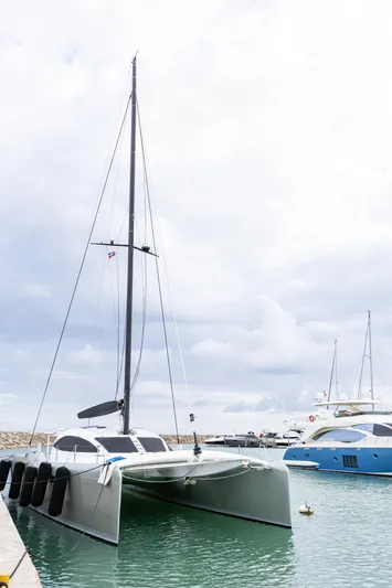  Yacht Photos Pics 2018 Tag 60 catamaran docked in marina, overcast sky, luxury yachts in background.