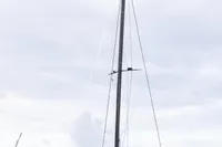 2018 Tag 60 catamaran docked in a marina under cloudy skies.