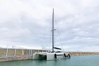 2018 Tag 60 catamaran docked at a marina under cloudy skies.