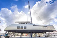 Sleek 2018 Tag 60 yacht on stands under a bright, cloudy sky.
