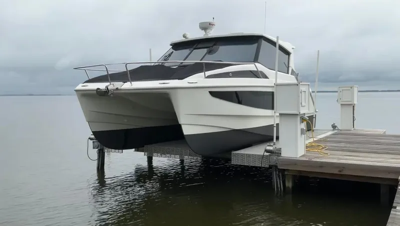  Yacht Photos Pics Aquila 36 Cruiser 2022 on dock lift, overcast sky, calm water.