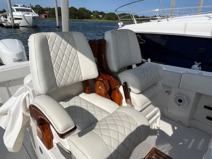  Yacht Photos Pics Luxurious seating on 2020 Jupiter 34 Center Console boat, featuring quilted upholstery and wooden accents.