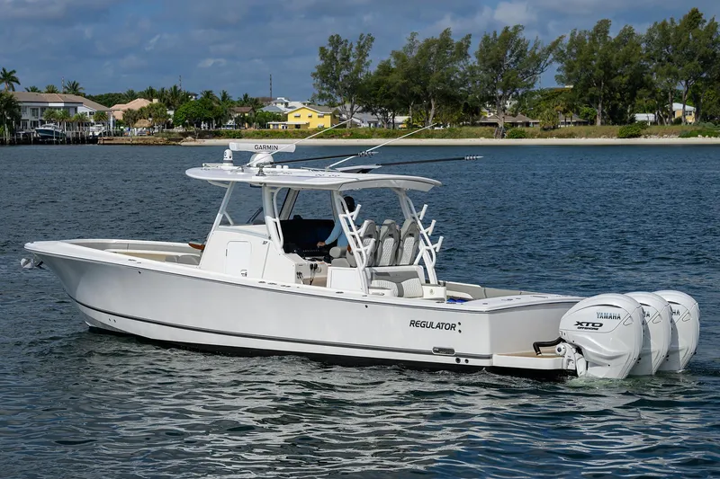  Yacht Photos Pics 2024 Regulator 37 boat on calm water, featuring triple Yamaha engines.