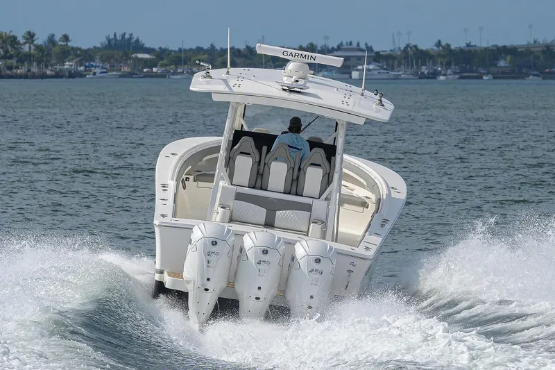  Yacht Photos Pics 2024 Regulator 37 boat cruising on water with triple outboard engines.