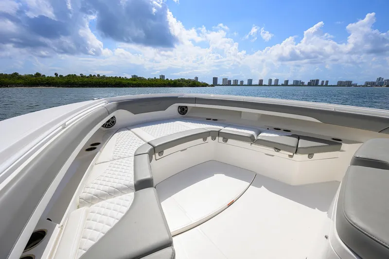  Yacht Photos Pics 2024 Regulator 37 boat interior with cushioned seating, overlooking a scenic waterfront skyline.