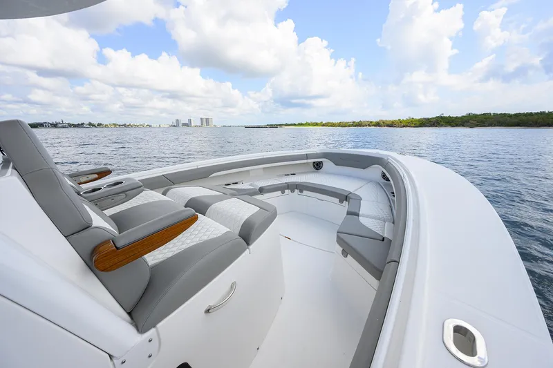  Yacht Photos Pics 2024 Regulator 37 boat with sleek seating, cruising on a calm waterway under a blue sky.