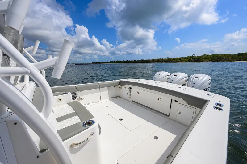  Yacht Photos Pics 2024 Regulator 37 boat with spacious deck and triple outboard engines on a sunny day.