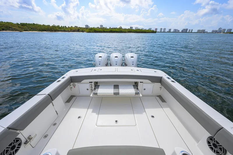  Yacht Photos Pics 2024 Regulator 37 boat deck with triple engines on a serene water backdrop.