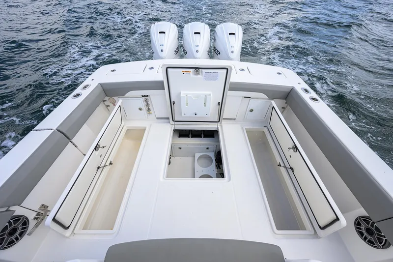  Yacht Photos Pics 2024 Regulator 37 boat deck with storage compartments and triple engines on water.