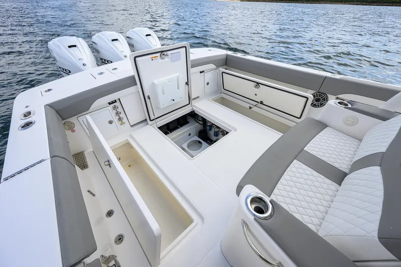  Yacht Photos Pics 2024 Regulator 37 boat interior with open storage compartments and triple engines on water.