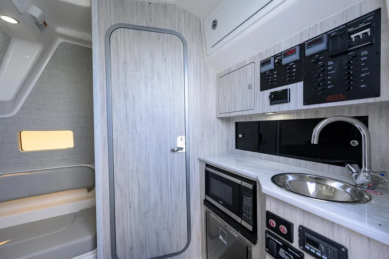  Yacht Photos Pics 2024 Regulator 37 interior with kitchenette, featuring sink, microwave, and control panels.