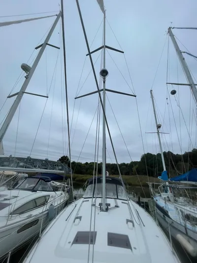 Joie De Vivre Yacht Photos Pics 2014 Beneteau Oceanis 48 sailboat docked, showcasing mast and deck under cloudy sky.