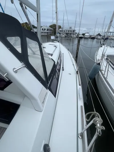 Joie De Vivre Yacht Photos Pics 2014 Beneteau Oceanis 48 sailboat docked in a marina, showcasing sleek design and spacious deck.