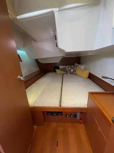 Joie De Vivre Yacht Photos Pics Interior cabin of 2014 Beneteau Oceanis 48 sailboat with twin beds and wooden finish.