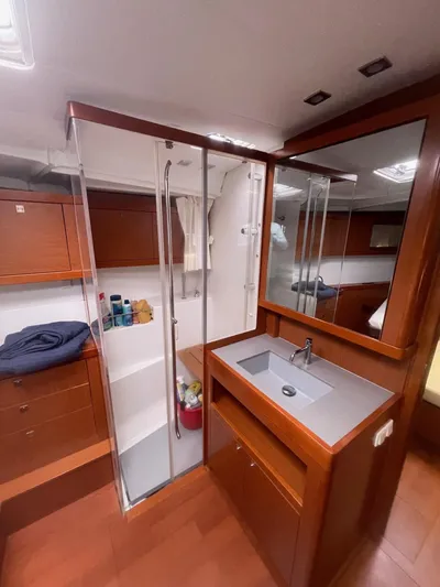Joie De Vivre Yacht Photos Pics Interior of 2014 Beneteau Oceanis 48 yacht bathroom with wooden cabinetry and modern fixtures.