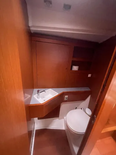 Joie De Vivre Yacht Photos Pics 2014 Beneteau Oceanis 48 yacht bathroom with wooden cabinetry and modern fixtures.