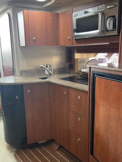  Yacht Photos Pics 2009 Cruisers Yachts 360 Express kitchen with wood cabinets, microwave, and sink.