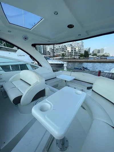  Yacht Photos Pics 2009 Cruisers Yachts 360 Express interior with seating and table, docked by waterfront buildings.