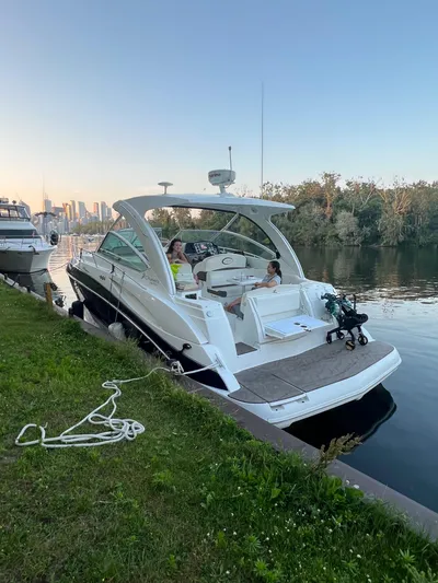  Yacht Photos Pics 2009 Cruisers Yachts 360 Express docked by a serene riverside with passengers onboard.