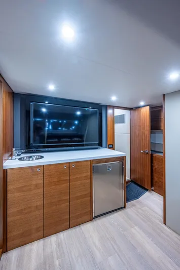 Ciento Siete Yacht Photos Pics Modern interior of 2020 Maritimo X50 yacht with TV, sink, and wooden cabinetry.