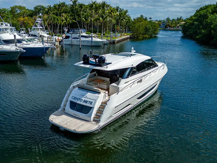 Ciento Siete Yacht Photos Pics 2020 Maritimo X50 yacht cruising in a marina with other boats and palm trees.