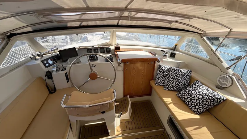 Indigo Yacht Photos Pics 1996 Amel Super Maramu-53 yacht cockpit with steering wheel, seating, and nautical decor.