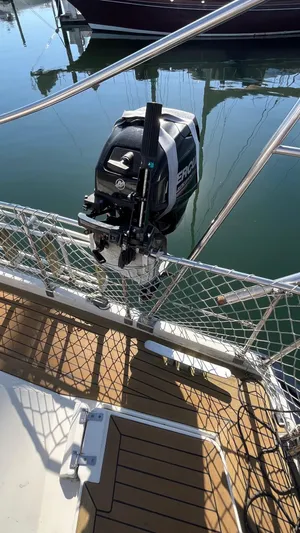 Indigo Yacht Photos Pics Outboard motor on 1996 Amel Super Maramu-53 sailboat, docked with safety netting.