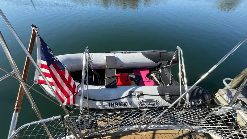 Indigo Yacht Photos Pics Inflatable boat docked beside 1996 Amel Super Maramu-53, displaying an American flag.