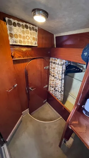 Indigo Yacht Photos Pics Interior of 1996 Amel Super Maramu-53 sailboat with wooden cabinetry and circular window.