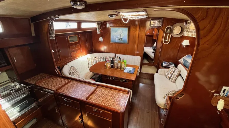 Indigo Yacht Photos Pics Interior of 1996 Amel Super Maramu-53 yacht with cozy seating and wooden finishes.