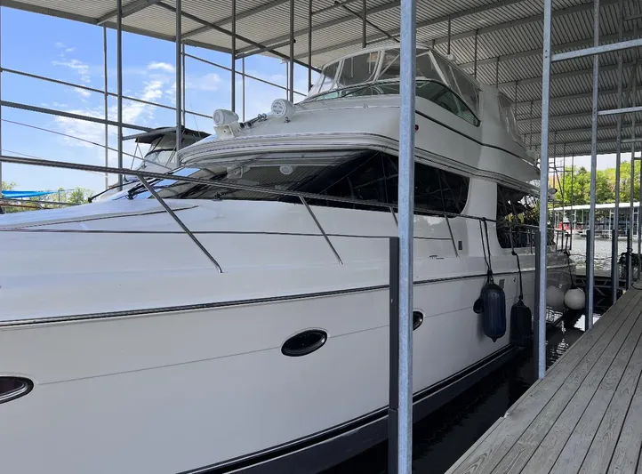 Flying Lady Yacht Photos Pics 2004 Carver 570 Voyager Pilothouse yacht docked under a covered marina.
