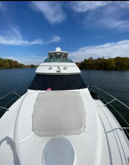 Flying Lady Yacht Photos Pics 2004 Carver 570 Voyager Pilothouse yacht on a serene lake under a blue sky.