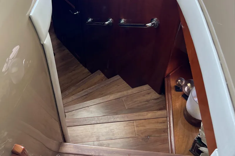 Flying Lady Yacht Photos Pics Wooden staircase inside 2004 Carver 570 Voyager Pilothouse yacht, featuring elegant handrails.