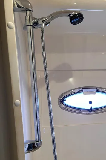 Flying Lady Yacht Photos Pics Shower area in 2004 Carver 570 Voyager Pilothouse with chrome fixtures and oval window.