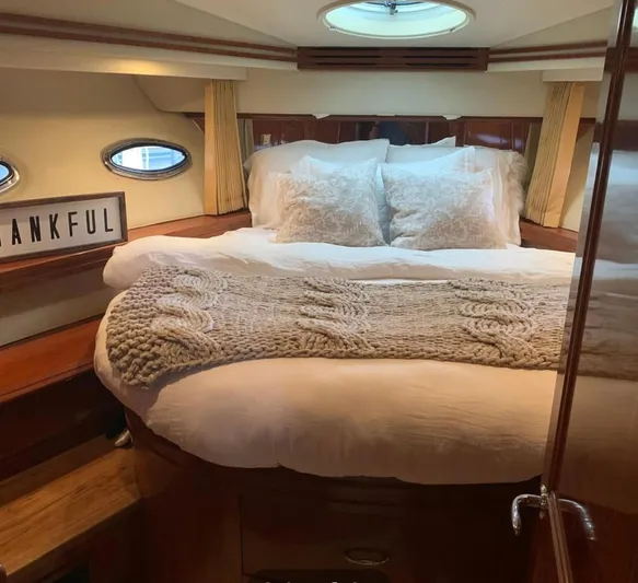 Flying Lady Yacht Photos Pics Cozy bedroom in 2004 Carver 570 Voyager Pilothouse with plush bedding and decorative sign.