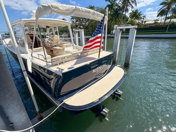 Moncri Yacht Photos Pics 2012 MJM 36z Downeast boat docked, displaying an American flag, with a sunny waterfront view.