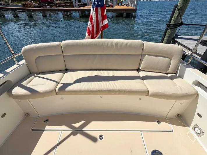 Moncri Yacht Photos Pics 2012 MJM 36z Downeast boat with beige seating and American flag, docked by the water.