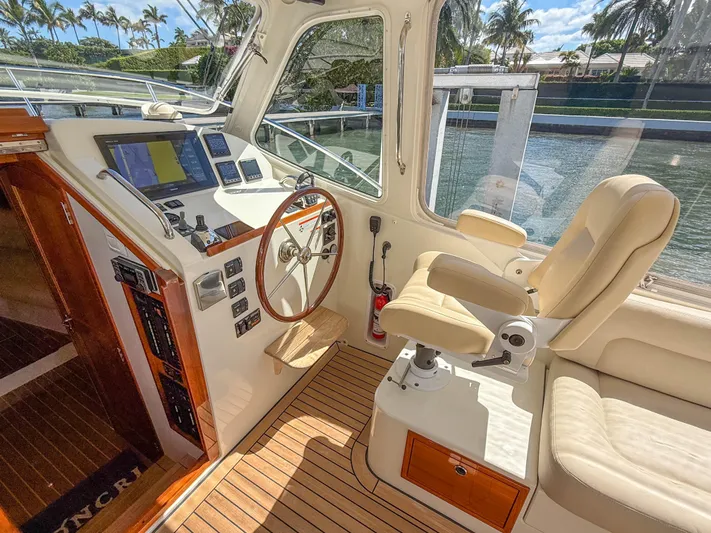 Moncri Yacht Photos Pics 2012 MJM 36z Downeast yacht helm with leather seat, wooden steering wheel, and navigation screens.
