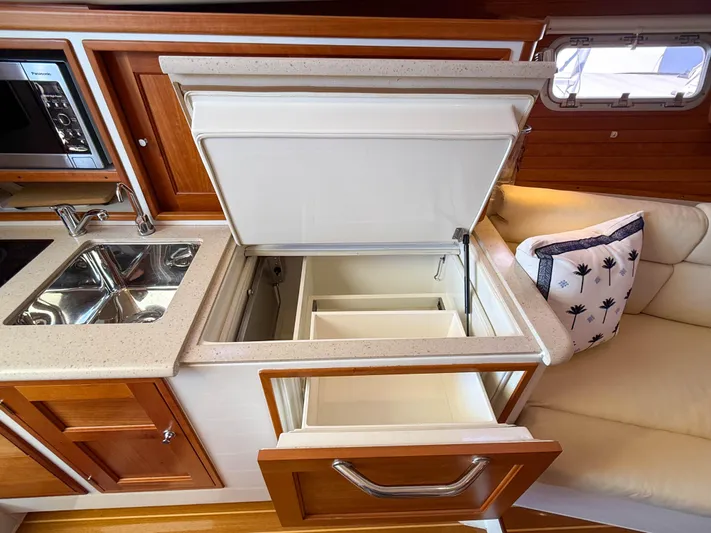 Moncri Yacht Photos Pics Interior of 2012 MJM 36z Downeast yacht showing kitchen with open fridge and sink.