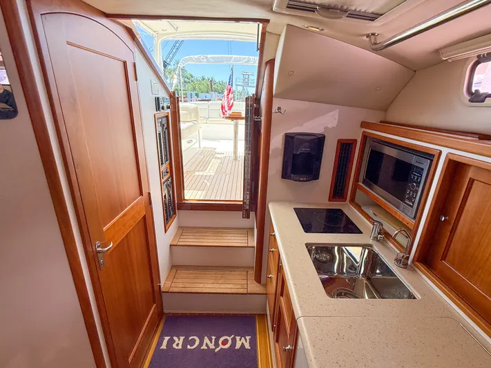 Moncri Yacht Photos Pics Interior of 2012 MJM 36z Downeast yacht with kitchenette and wooden cabinetry.