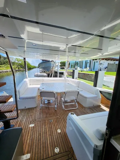  Yacht Photos Pics 2019 Galeon 640 Fly yacht with spacious deck and seating area, docked by a canal.