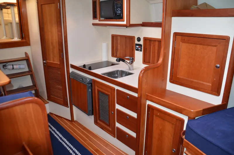 Patriot Yacht Photos Pics 2003 Little Harbor WhisperJet 38 yacht interior with wooden cabinetry and compact kitchen area.
