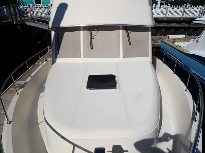 No Quarter Yacht Photos Pics 2006 Mainship 34 Trawler boat deck with railing and hatch, docked at marina.