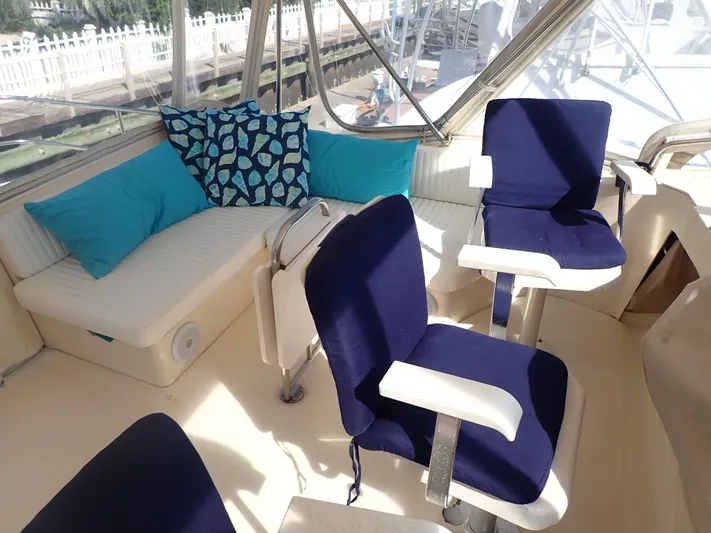 No Quarter Yacht Photos Pics Interior of 2006 Mainship 34 Trawler with blue seating and decorative pillows.