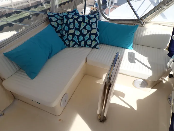 No Quarter Yacht Photos Pics 2006 Mainship 34 Trawler interior with white seating and blue decorative pillows.