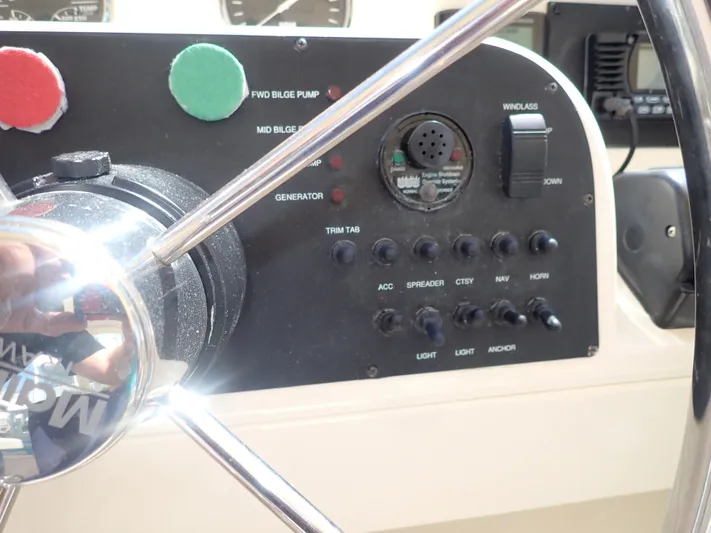 No Quarter Yacht Photos Pics Control panel of a 2006 Mainship 34 Trawler with steering wheel and switches.