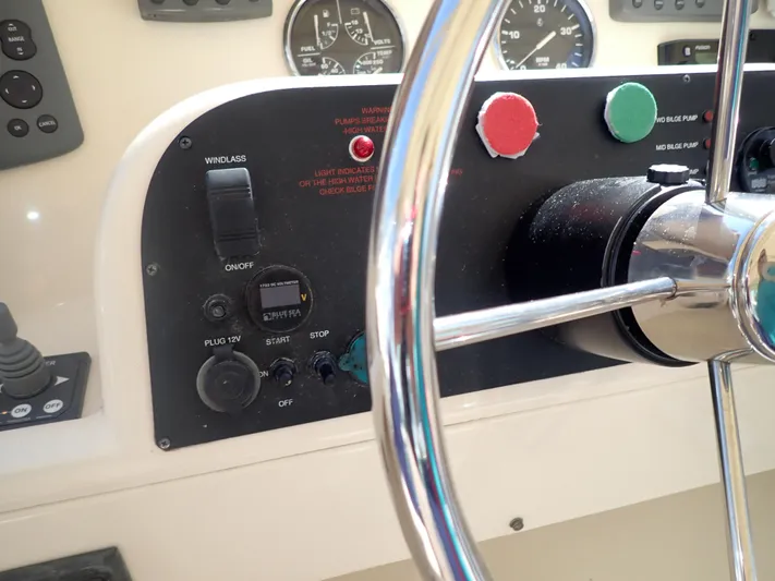 No Quarter Yacht Photos Pics Control panel of a 2006 Mainship 34 Trawler with steering wheel and gauges.