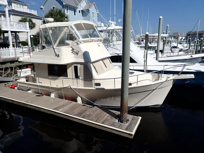 No Quarter Yacht Photos Pics 2006 Mainship 34 Trawler docked at a marina, surrounded by other boats.